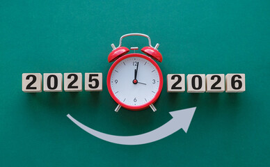 A red alarm clock with the numbers 2025 and 2026 on it