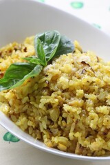 Basil and shiitake mushroom risotto, a vibrant yellow rice dish garnished with fresh herbs. Created by Master Chef Hans Chunseop.