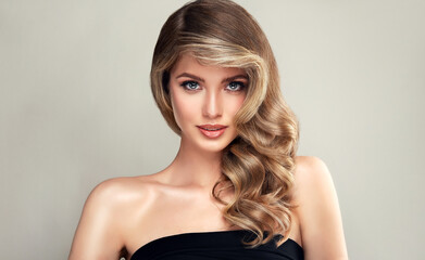 Beautiful laughing blonde model  girl  with long curly  hair . Smiling  woman hairstyle wavy curls .     Fashion , beauty and makeup portrait
