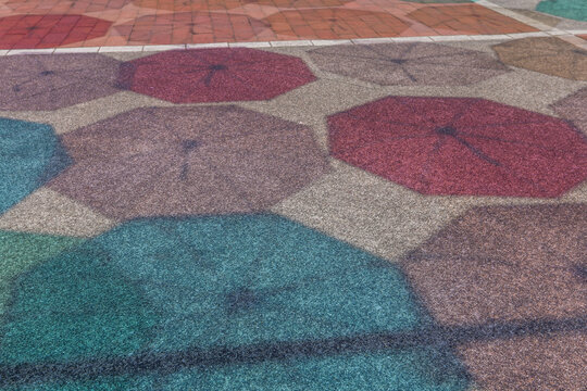 夏の晴れた日に、地面に映る色とりどりの傘の影