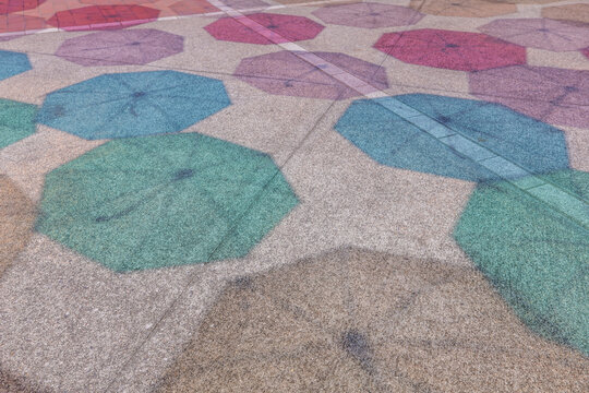 夏の晴れた日に、地面に映る色とりどりの傘の影