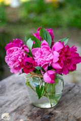 Beautiful bouquet of summer peonies flowers in a glass vase 