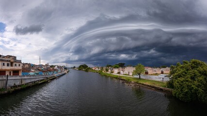 Fototapeta premium Dramatic storm clouds over a city river.