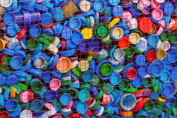 Heart-shaped metal container filled with plastic caps for recycling in public eco campaign