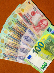 Currency Value Comparison: 100 Euros Equals 2,700,000 Vietnamese Dong in Colorful Display