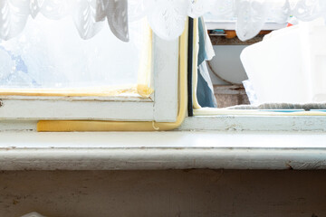 Old wooden window with foam insulation in the apartment, view from the window sill, elements of the old Soviet interior