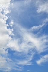 Obraz premium Vertical bright blue sky background with cluster of fluffy and smoky white clouds.Nature , beautiful weather,sky in sunny day, sky landscape.