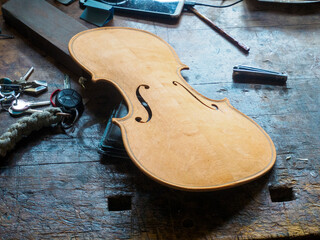 Craftsman Working on a Violin Body a Detailed CloseUp View of the Unfinished Instrument in a Workshop Setting Showing Tools and Materials Used in its Creation