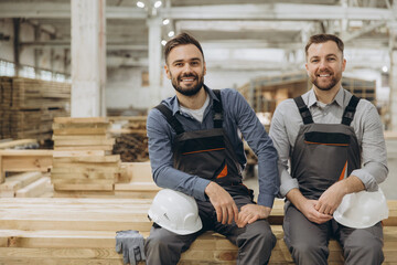 Carpenters smiling in lumber warehouse, modular building industry