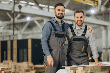 Engineers hugging and smiling in modular building factory