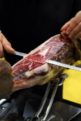 experto en el corte de paletas de jam&oacute;n ib&eacute;rico cortando con un cuchillo de corte lonchas de jam&oacute;n ib&eacute;rico