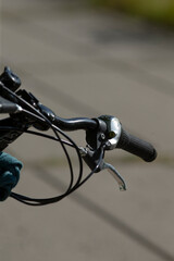 This image presents a closeup view featuring a person riding a bicycle along a sidewalk in a vibrant urban environment