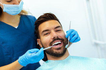 Female Dentist Treating Male Patient&rsquo;s Teeth