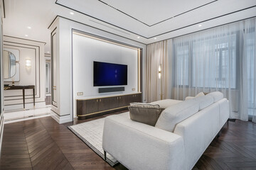 Fototapeta premium The interior of an elegant neoclassical-style living room with modern furniture and large windows filling the space with soft natural light.