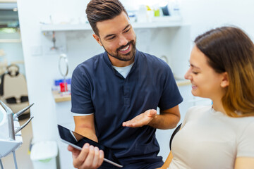 Male Dentist Showing Information on Tablet to Female Patient