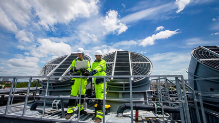 Technicians evaluate cooling system performance on rooftop during sunny day