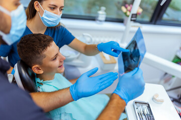 Male Dentist Showing Dental X-Ray to Young Boy