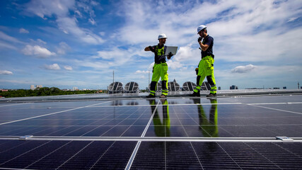Workers install solar panels on a rooftop in a bright urban environment with blue skies
