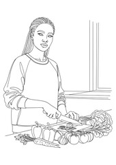 A woman with braided hair is focused on chopping vegetables in her kitchen.