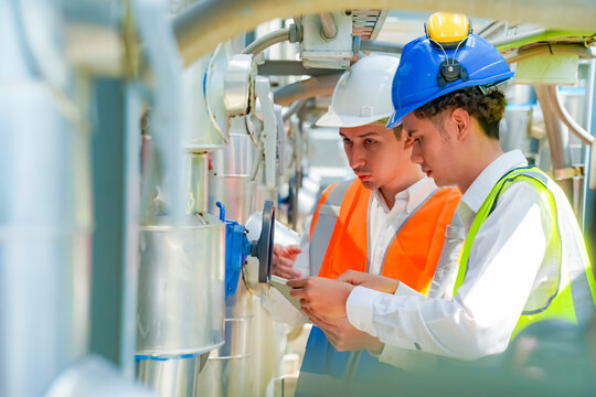 Engineers collaborating on system analysis at an industrial site during daylight hours