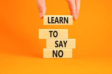 Learn to say no symbol. Concept words phrase Learn to say no on beautiful wooden blocks. Beautiful orange paper background. Businessman's hand Business psychological Learn to say no concept Copy space