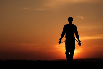 Silhouette Walking into Sunrise with Chains Falling Behind
