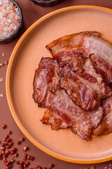 Cooked fried crispy bacon as an ingredient of a delicious English breakfast. Pieces of fried bacon