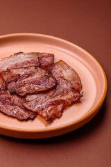 Cooked fried crispy bacon as an ingredient of a delicious English breakfast. Pieces of fried bacon