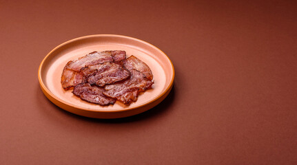Cooked fried crispy bacon as an ingredient of a delicious English breakfast. Pieces of fried bacon
