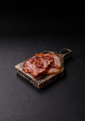 Cooked fried crispy bacon as an ingredient of a delicious English breakfast. Pieces of fried bacon