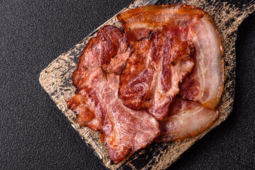 Cooked fried crispy bacon as an ingredient of a delicious English breakfast. Pieces of fried bacon