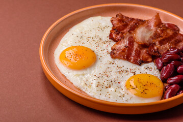 Fried egg, bacon and beans, a classic British breakfast with tomatoes. Egg, bacon and beans