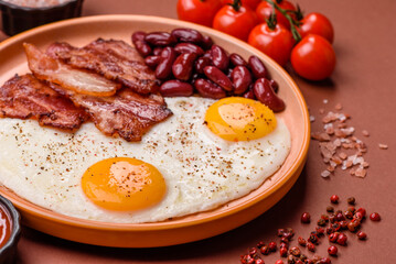 Fried egg, bacon and beans, a classic British breakfast with tomatoes. Egg, bacon and beans