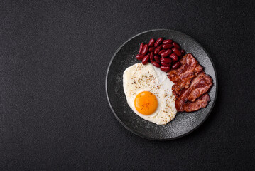 Fried egg, bacon and beans, a classic British breakfast with tomatoes. Egg, bacon and beans