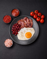 Fried egg, bacon and beans, a classic British breakfast with tomatoes. Egg, bacon and beans