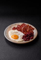 Fried egg, bacon and beans, a classic British breakfast with tomatoes. Egg, bacon and beans