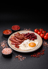 Fried egg, bacon and beans, a classic British breakfast with tomatoes. Egg, bacon and beans