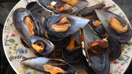 Freshly cooked mussels on decorative plate for seafood dining experience