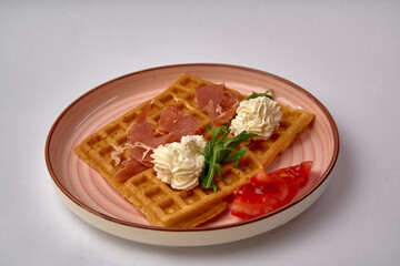 Deliciously Crafted Waffles Topped with Savory Ham and Creamy Whipped Topping, Enhanced with Fresh Tomato and Verdant Greens for a Flavorful Harmony