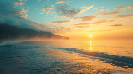 Obraz premium Golden sunrise over the ocean with misty coastline. Serene seascape with soft light and calm waters.