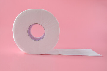 Tissue rolls of toilet paper lying on pink background.