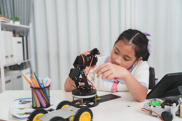 A young engineer uses a tool to build a robot. STEM and mechanics concept.