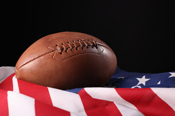 American football ball and USA flag. Sport game. Super bowl in US. Football ball Close Up macro photography with copy space.