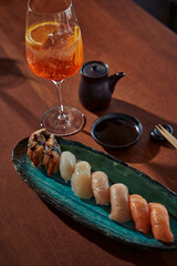 A Vibrant Culinary Experience Featuring Exquisite Sushi and a Refreshing Drink on a Rustic Wooden Table