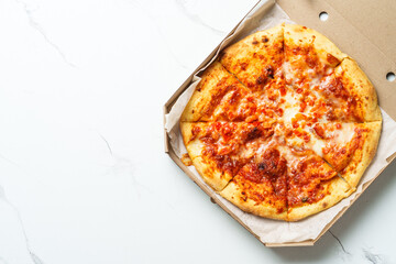 Pizza Margarita in a cardboard box on white background.