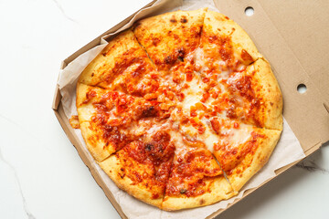 Pizza Margarita in a cardboard box on white background.