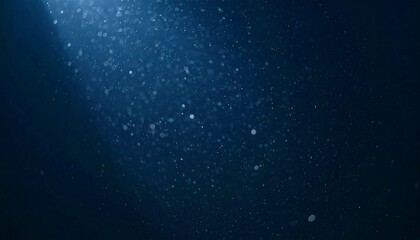 Floating dust particles illuminated by a single cinematic beam of light on a dark gradient background