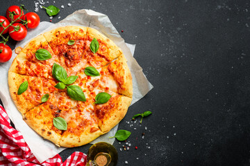 Pizza margarita on black background with ingredients for cooking.