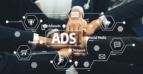 A group of business professionals join hands to symbolize collaboration in advertising and social...