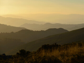 An endless succession of mountains and hills, backlit at sunset